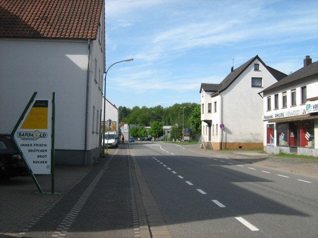 a broad street in a german town with a sign in the foreground for the bakery
